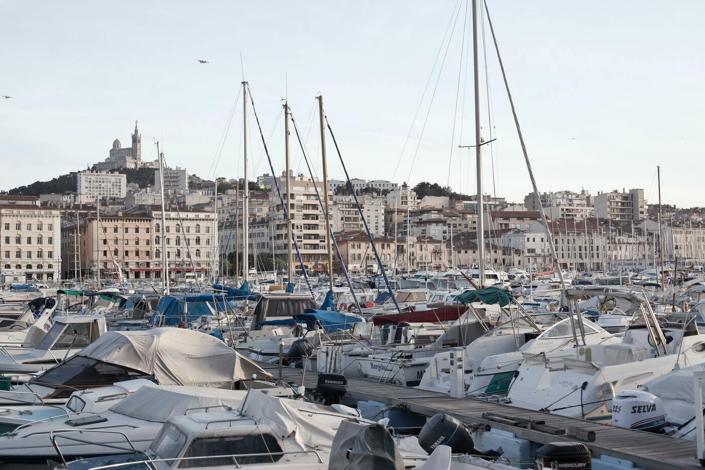 Stationnement de différents bateaux sur le Vieux-Port et vue sur les différents batiments, notamment l'église.