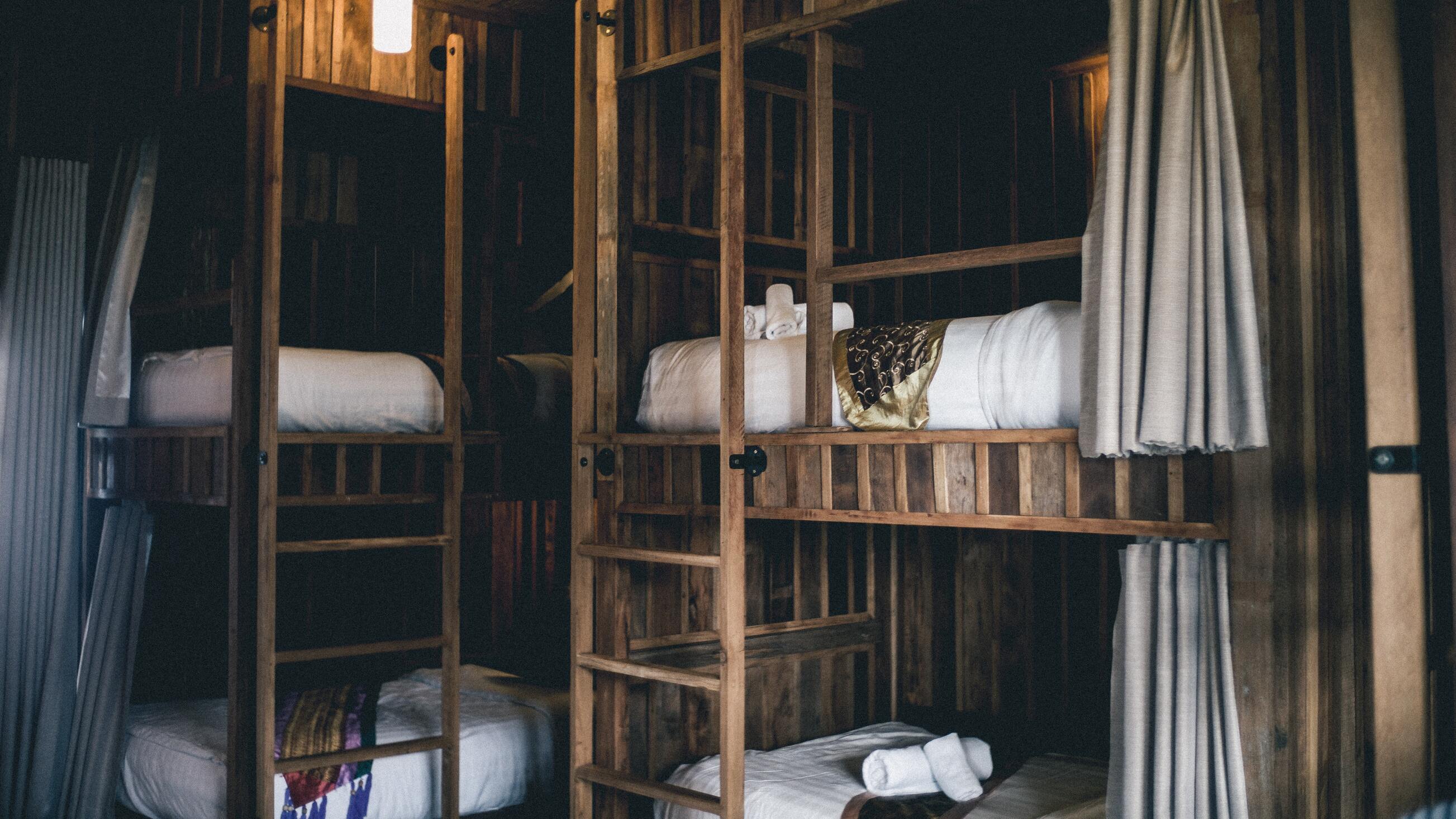 Pièce à coucher avec deux lits superposés en bois, offrant chacun deux place de couchage.